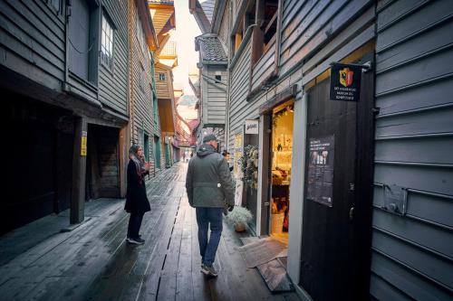 a man walking down a narrow street with a woman at Hotel Oleana in Bergen