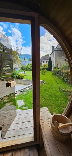 an open door to a patio with a view of a yard at Gîte Eth Chalèt 4 étoiles Les Échappées Belles in Antignac