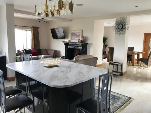a kitchen and living room with a marble table and chairs at Serene luxurious Retreat with Sea Views, Entire Home Letterkenny in Letterkenny