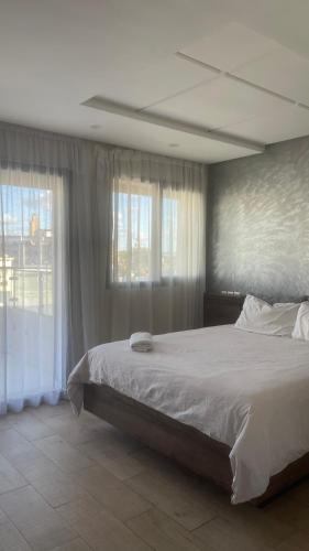 a bedroom with a large bed and two windows at Appartement centre ville kenitra in Kenitra
