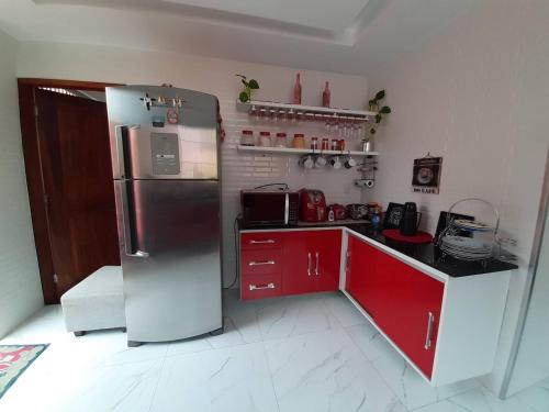 a kitchen with a stainless steel refrigerator and red cabinets at Casa para COP 30 in Belém