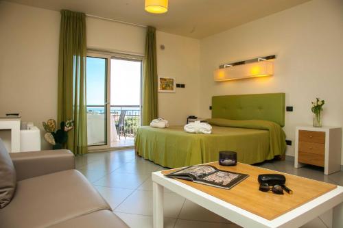 a hotel room with a bed and a coffee table at 4 Spa Resort Hotel in Catania