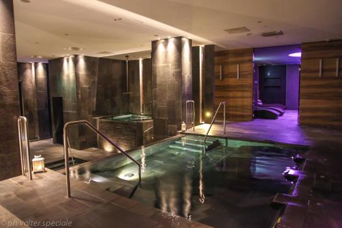 a bath room with a tub and a pool in it at 4 Spa Resort Hotel in Catania