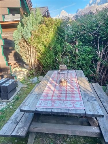une table de pique-nique avec une lanterne dessus dans l'établissement Cosy Petite Chalet T3, Jardin, Terrasse, Parking. Chamonix Mont-blanc., aux Houches