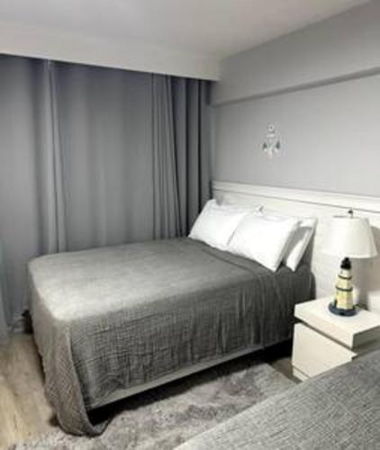a bedroom with a bed and a lamp on a night stand at Ocean View Condo in Daytona Beach