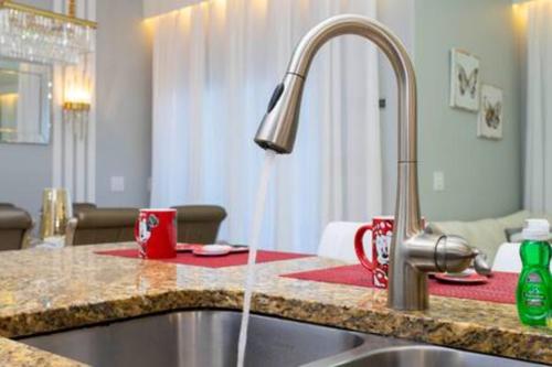 a kitchen sink with a faucet and two coffee mugs at 4 Bedrooms3 Bathrooms at Storey Lake Resort in Kissimmee