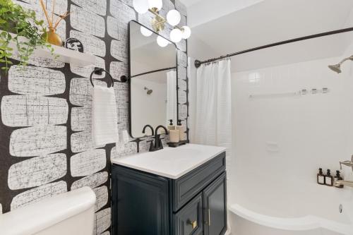 a bathroom with a black and white brick wall at Comfy 2BR Condo near Uptown & NoDa Free Parking in Charlotte