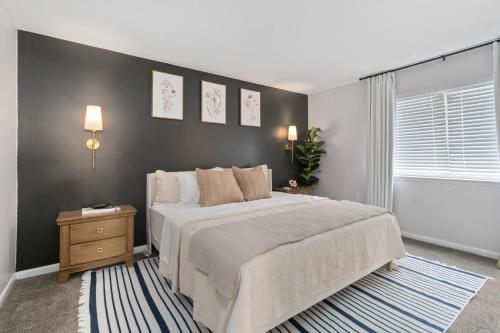 a bedroom with a bed and a black wall at Comfy 2BR Condo near Uptown & NoDa Free Parking in Charlotte