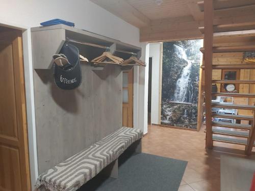 a bench in a room with a hat on the wall at Chaty Pod Dlhou Podbanské in Pribylina