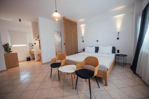 a bedroom with a bed and two chairs and a table at Thirsty Dog Urban Port Studios in Igoumenitsa