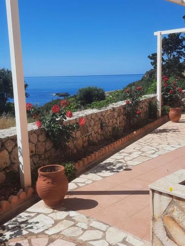 a stone retaining wall with flowers on a patio at Asta La Vista Maisonettes in Pesádha