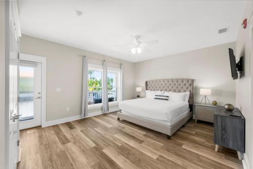 a white bedroom with a bed and a window at Beach House - Marina View by Panhandle Getaways in Port Saint Joe