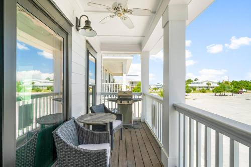 a porch with chairs and a table and a ceiling fan at Beach House - Marina View by Panhandle Getaways in Port Saint Joe