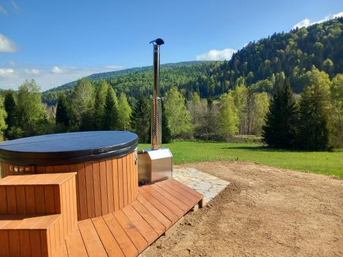 a hot tub on a deck with a view of a mountain at Chata pod Jelenim Skokiem in Cisna