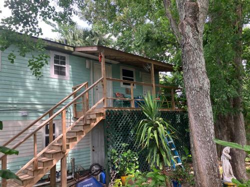 a house with a porch with a wooden deck at Green garden view in New Orleans