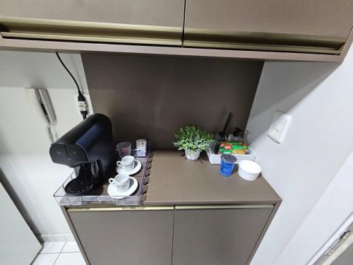 a small kitchen with a stove and cups and plants at 1027 Apartamento Luxuoso! in Ribeirão Preto