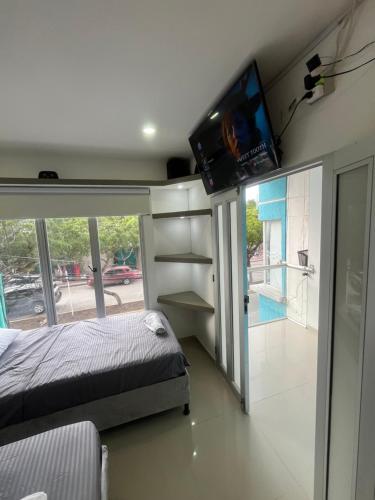 a bedroom with a bed and a tv on the wall at Apartamentos amoblados Puerto Nuevo in Ríohacha