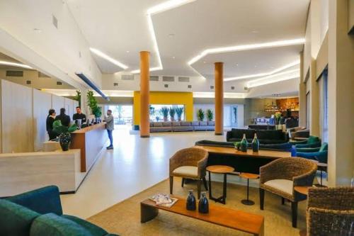 a lobby of a hotel with couches and a bar at Enjoy Olimpia Park Resort in Olímpia