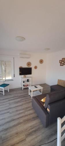 a living room with a couch and a table at Apartamentos Serranheira in Costa de Santo André