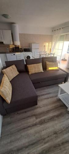a living room with a couch and a kitchen at Apartamentos Serranheira in Costa de Santo André
