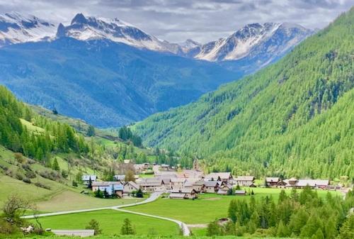 a village in the middle of a valley with mountains at Les granges d'Arvieux vue sur le Queyras in Arvieux