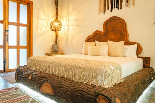a bedroom with a large bed with a large wooden headboard at Anzalik Hotel Boutique in Anzá