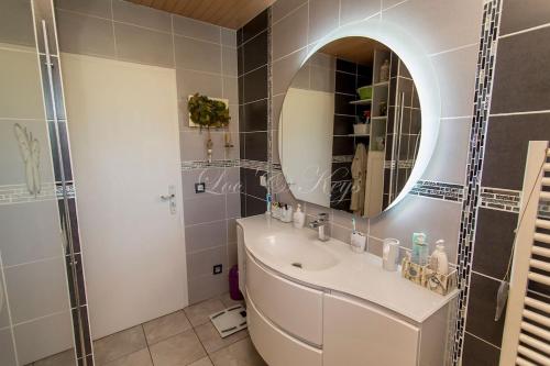 une salle de bain avec un lavabo et un miroir dans l'établissement Maison landaise, à Biscarrosse