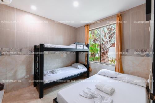 two bunk beds in a room with a window at Caribbean Town Tolu in Tolú