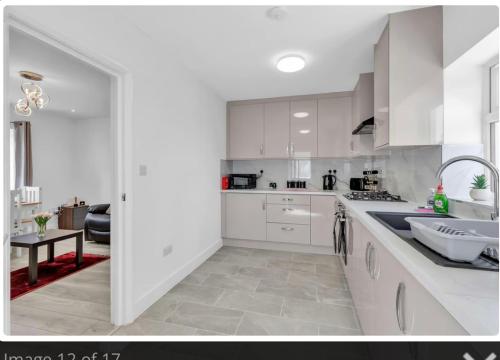 a white kitchen with white cabinets and a sink at Kemptown Corner with Free Parking in Brighton & Hove