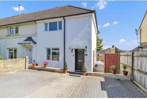 a white house with a gate and a fence at Kemptown Corner with Free Parking in Brighton & Hove
