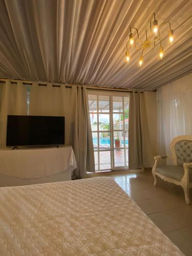 a bedroom with a bed and a tv and a chair at Valle Suites, la Mejor Ubicación in Valledupar