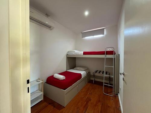 a small room with a bunk bed with a red mattress at Complejo Turistico Open Club in Paraná