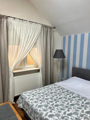 a bedroom with a bed and a window at Pokoje Gościnne Lidka in Dziwnów