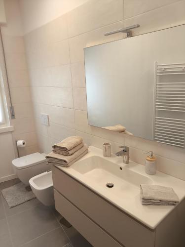 a bathroom with a sink and a toilet and a mirror at Dormire Negrar in Negrar