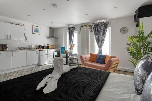 a living room with a bed and a kitchen at City Centre Studio Apartments - Stoop Apartment - Short Stays UK Ltd in Exeter