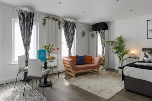 a bedroom with a bed and a chair and a table at City Centre Studio Apartments - Stoop Apartment - Short Stays UK Ltd in Exeter