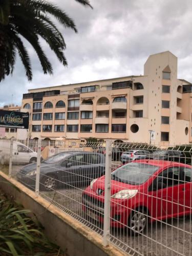 une voiture rouge garée devant un bâtiment dans l'établissement Studio des Quilles, à Sète