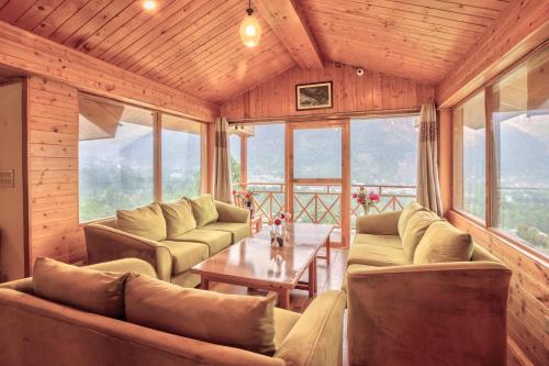 a living room with couches and a table at V V Aero a wooden exotic stay Near Old Manali in Manāli