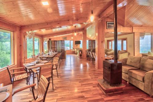 a living room with tables and chairs and a wood stove at V V Aero a wooden exotic stay Near Old Manali in Manāli