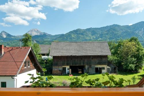 an old barn with mountains in the background at Gästehaus Lutschounig in Faak am See