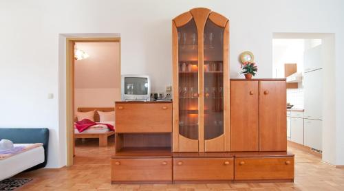 a large wooden cabinet with a mirror in a living room at Gästehaus Lutschounig in Faak am See