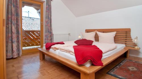 a bedroom with a bed with a red blanket on it at Gästehaus Lutschounig in Faak am See