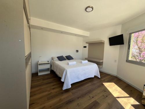 a bedroom with a white bed and a window at Complejo Turistico Open Club in Paraná
