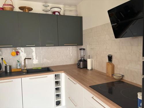 une cuisine avec des armoires blanches et un comptoir dans l'établissement Bel appart 3 ch centre et parking, à Tours