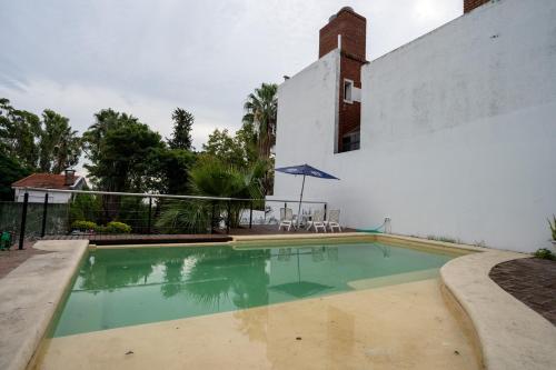 a swimming pool in front of a white building at Complejo Turistico Open Club in Paraná