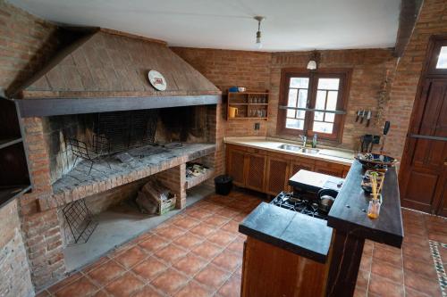 a kitchen with a stone fireplace and a sink at Complejo Turistico Open Club in Paraná