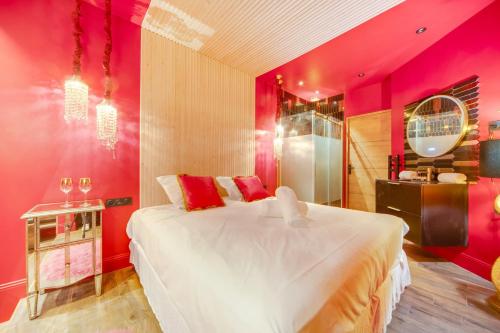 - une chambre avec un grand lit blanc et des murs rouges dans l'établissement Love & Room SPA Week-End, à Paris