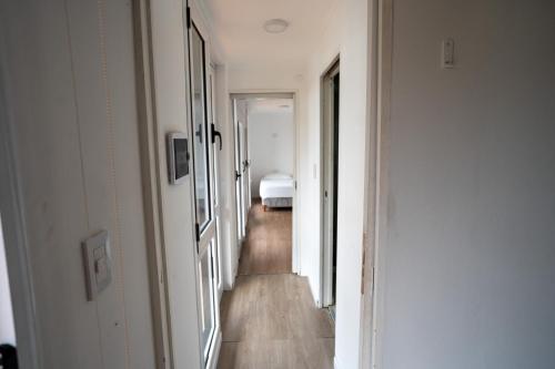 a hallway leading to a bedroom with a bed at Complejo Turistico Open Club in Paraná