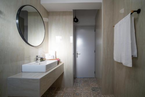 a bathroom with a white sink and a mirror at Leros Houses Sea View 2 in Lépidha