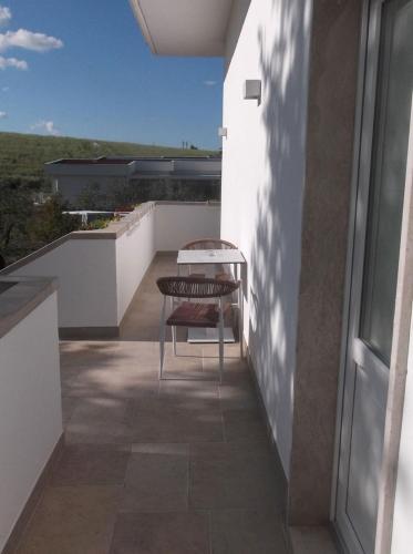 a balcony with a table and a bench on a building at L'Amarena Garden House in Matera